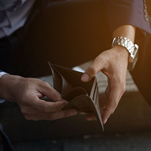 Person holds an empty wallet, symbolizing financial distress or bankruptcy.