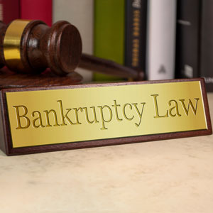 A golden nameplate reading 'Bankruptcy Law' with a gavel and books in the background.