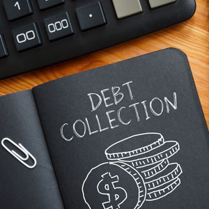 Black notebook with 'DEBT COLLECTION' and coins, paperclip, and calculator on a wooden desk.