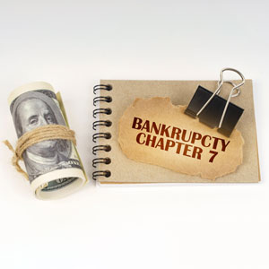 Notebook with 'BANKRUPTCY CHAPTER 7' and money, symbolizing assets in bankruptcy.