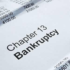 Close-up of a document titled 'Chapter 13 Bankruptcy' with financial figures.