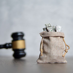 Gavel beside a burlap sack full of cash, for Charleston Chapter 13 bankruptcy attorney.